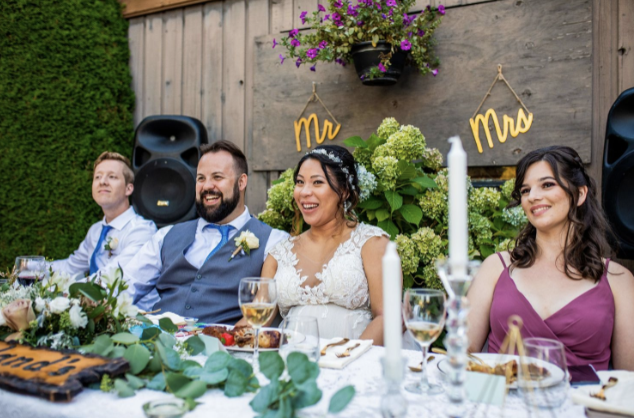 Newlyweds at the dinner table at their backyard wedding ceremony in BC