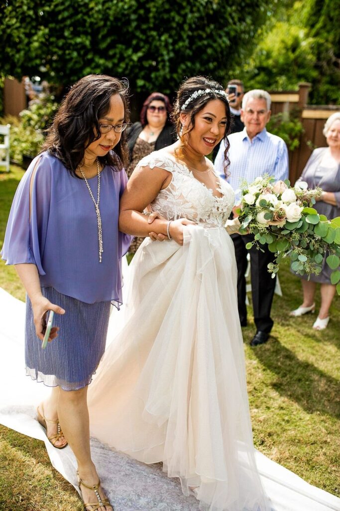 Mom walking daughter down the aisle at a backyard wedding ceremony in BC