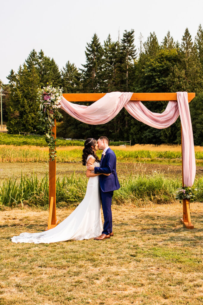 Bride and groom kissing at Vancouver Island Wedding ceremony At Enrico Winery