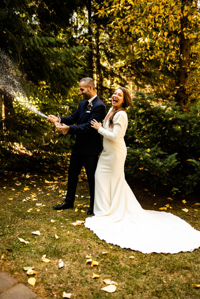 Couple popping champagne at their Whistler wedding