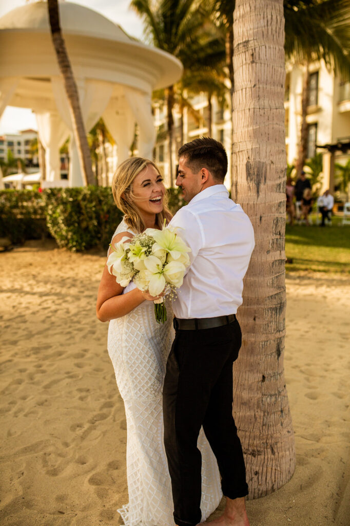 Newlyweds laughing and embracing after their Cabo San Lucas wedding