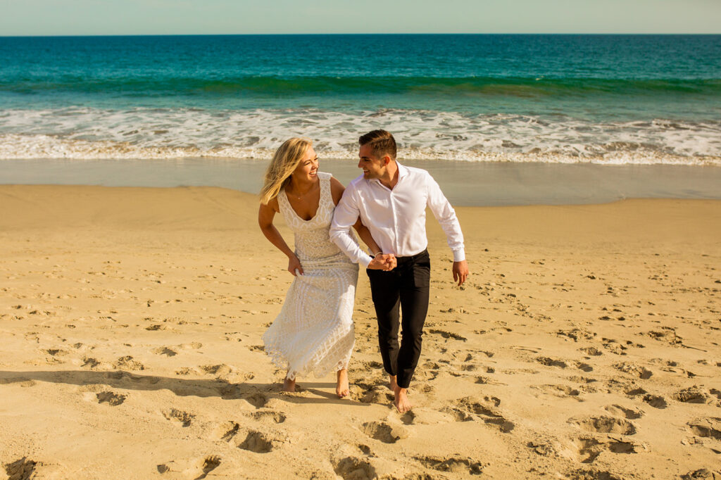 Couples portrait running on the beach in Cabo San Lucas