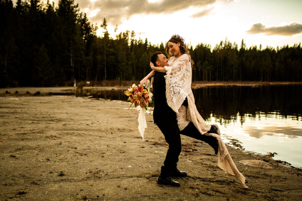 Groom picking up bride in a Whonnock Lake wedding editorial shoot