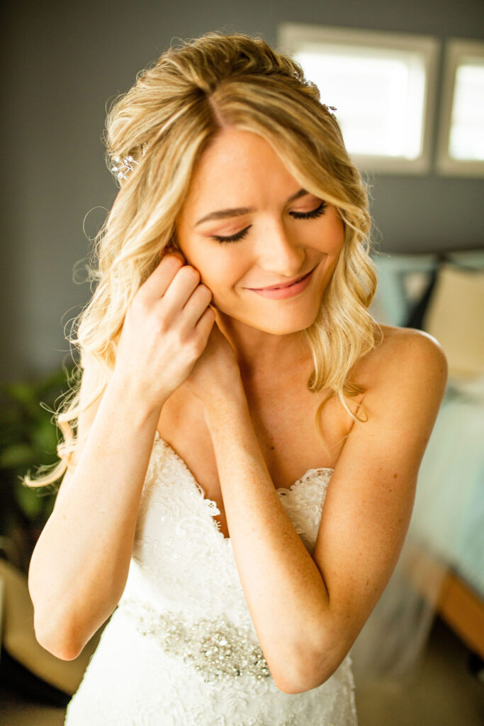 Bride putting on jewelery for her Redwoods Golf Course Wedding