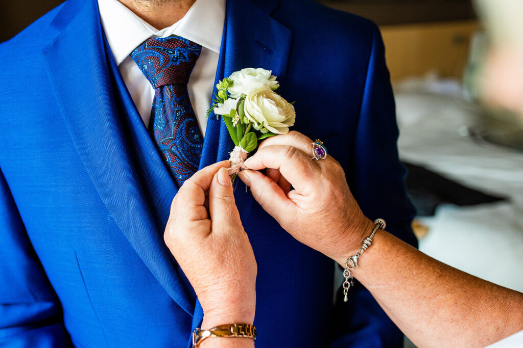 Groom getting flower put on his suit at his Kelowna wedding