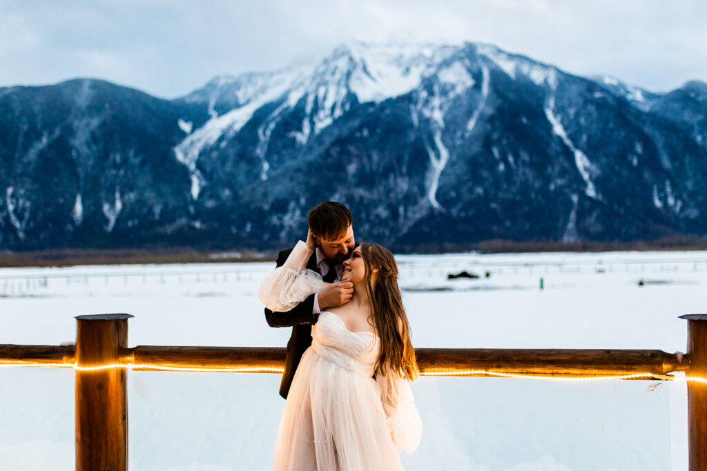 Newlyweds embracing with a dramatic mountain backdrop