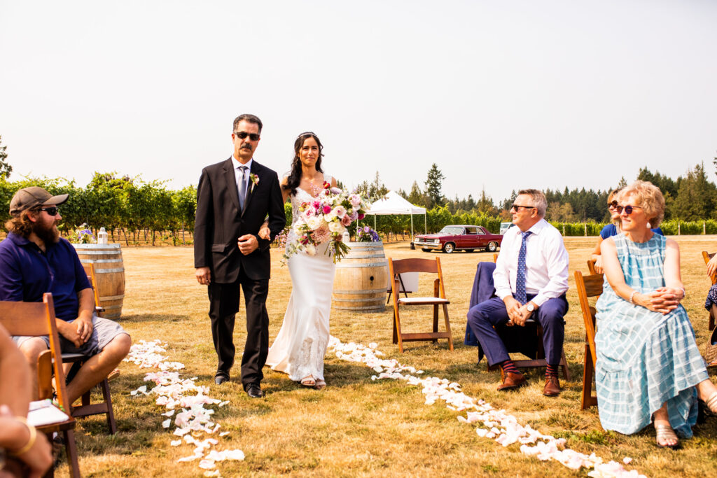 Bride being walked down the aisle Vancouver Island Wedding At Enrico Winery