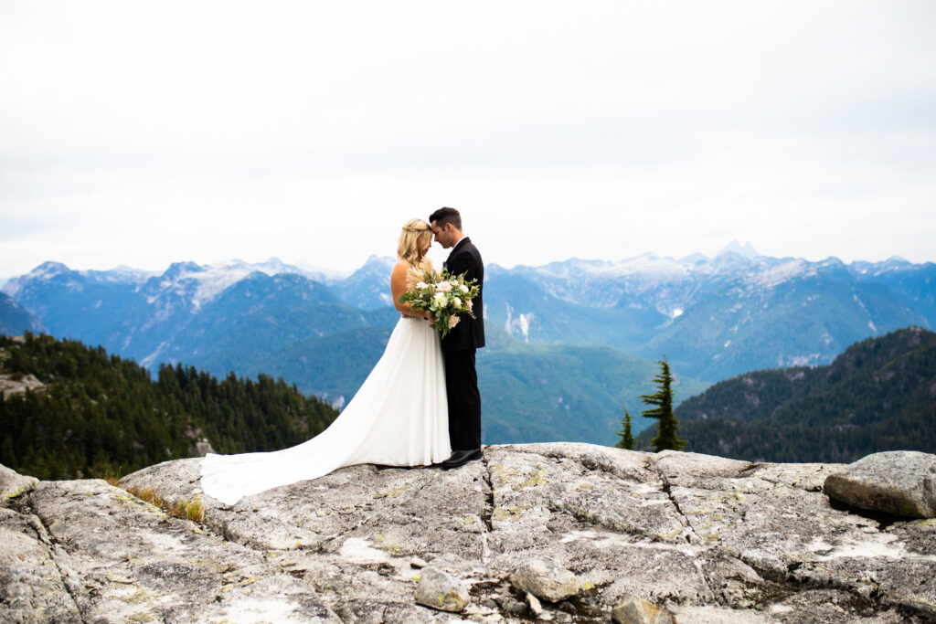 Couple gazing at each other on top of a mountain at their heli wedding