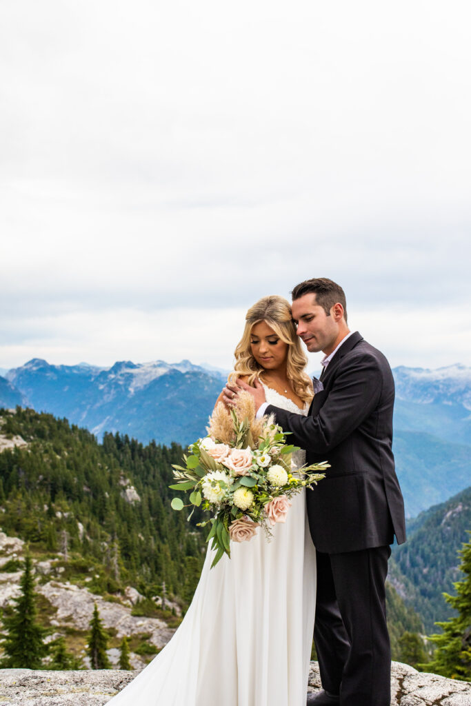 Gorgeous photo of newlyweds on a mountaintop at their heli wedding
