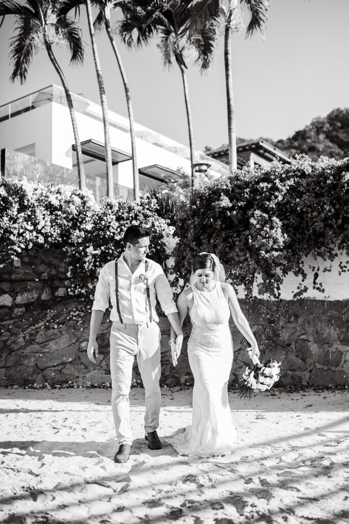 Black and white photo of couple walking on the beach at their Cabo San Lucas wedding