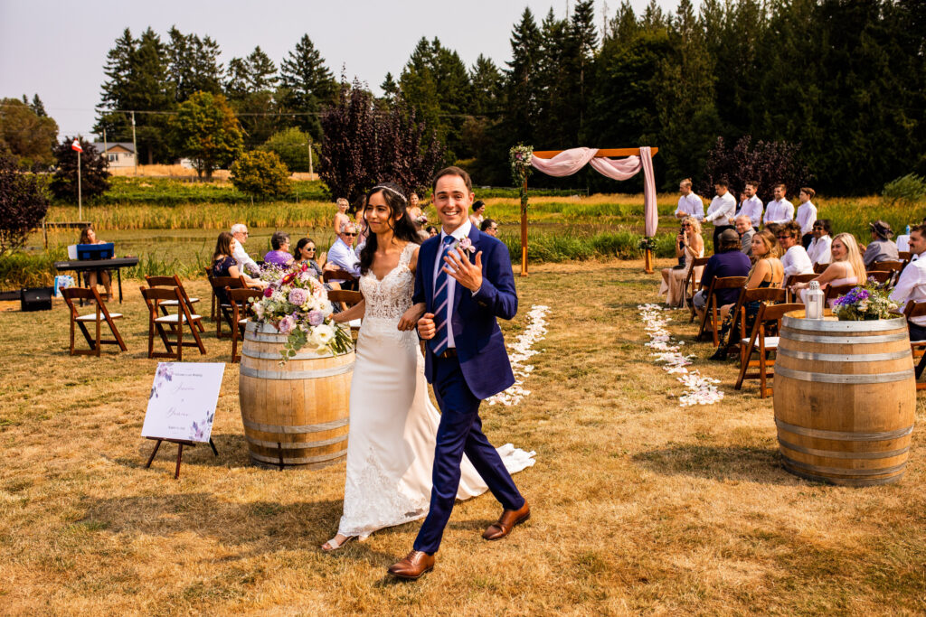 Newlyweds walking back down aisle Vancouver Island Wedding At Enrico Winery