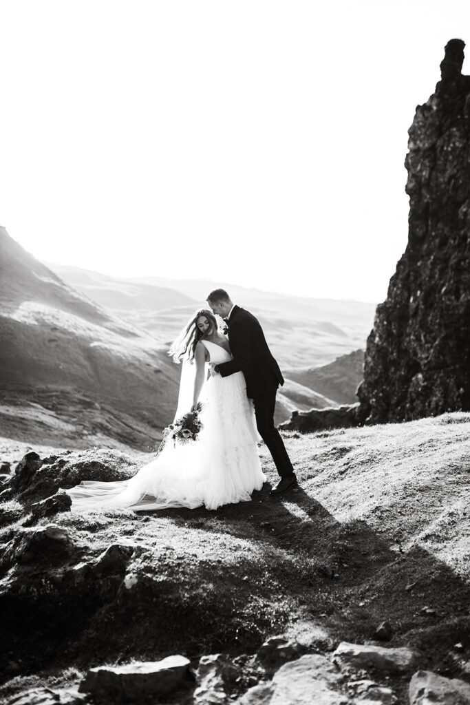 Black and white photo of bride and groom on a mountain