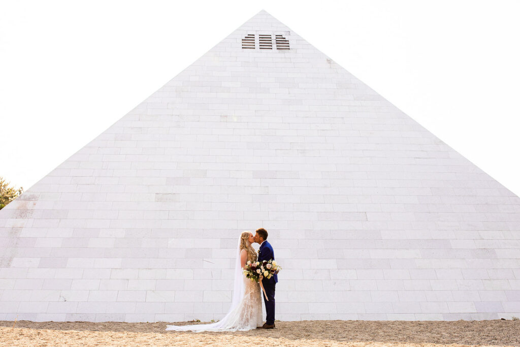 Newlyweds kissing in front of the Summerhill Pyramid Winery wedding venue