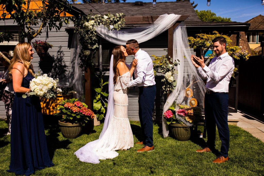 Bride and groom kiss at an intimate backyard wedding reception

