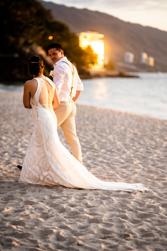 Newlyweds taking a romantic walk along the beach after their Cabo San Lucas wedding