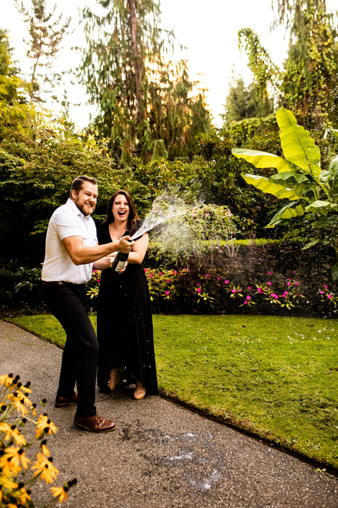 Couple popping champagne during their engagement shoot in Vancouver