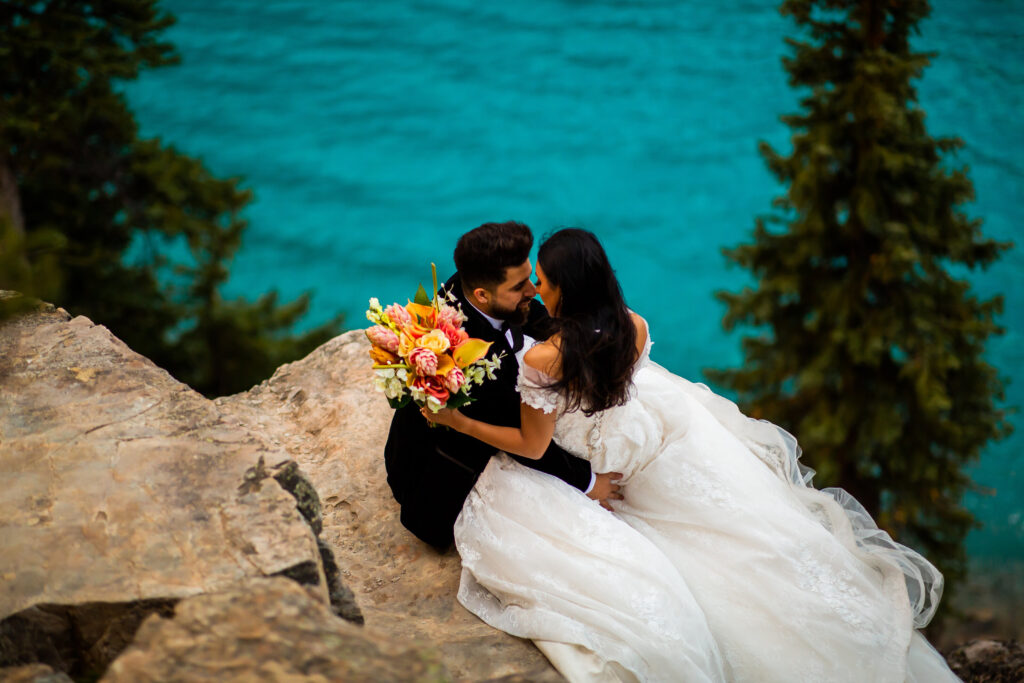 Bride and groom kissing on mountaintop in BC