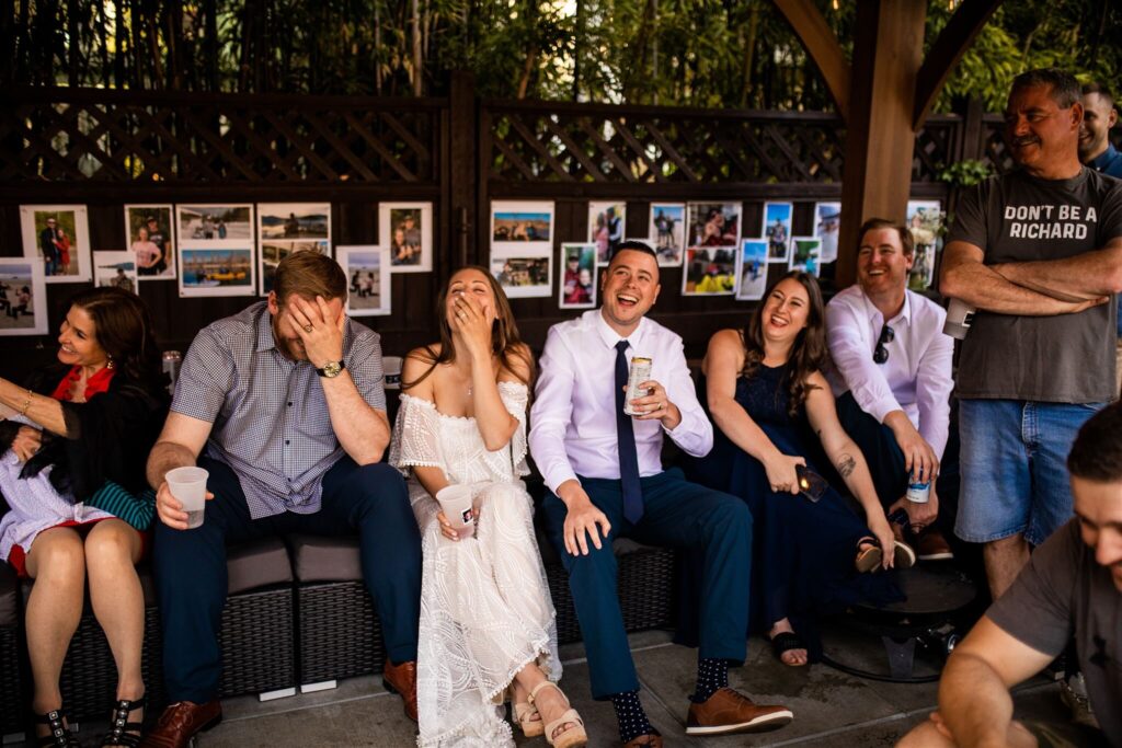 Bride and groom laughing at their backyard wedding reception
