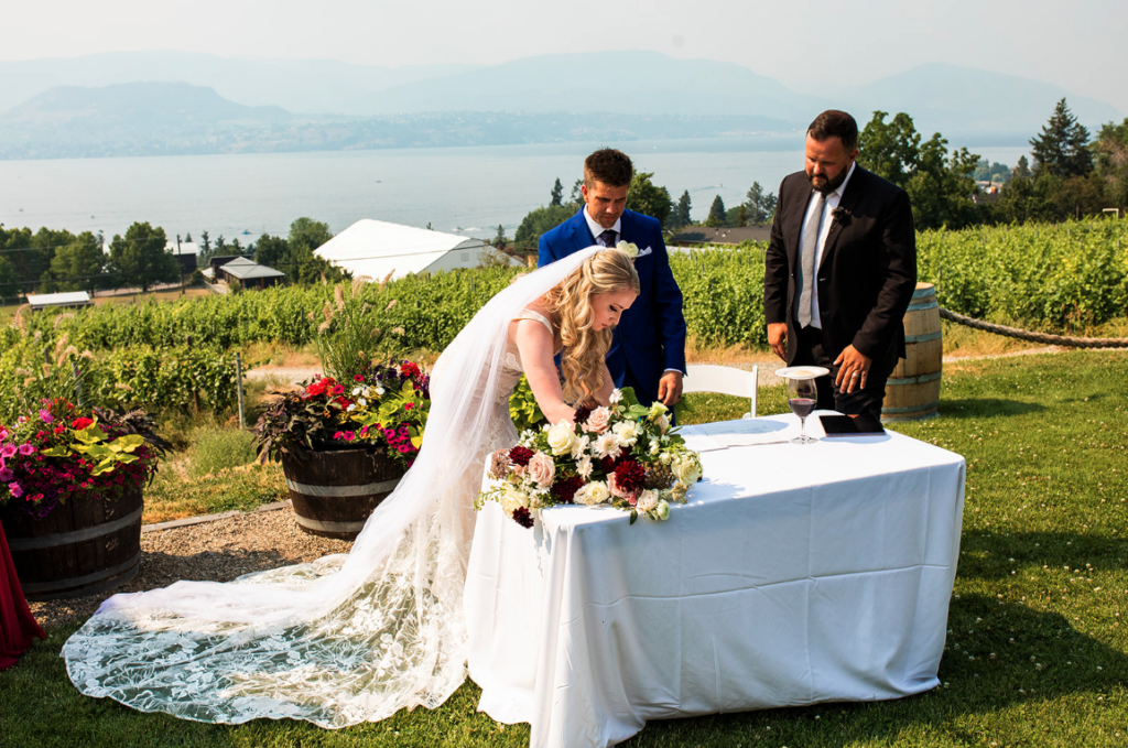Couple signing papers at Okanagan wedding