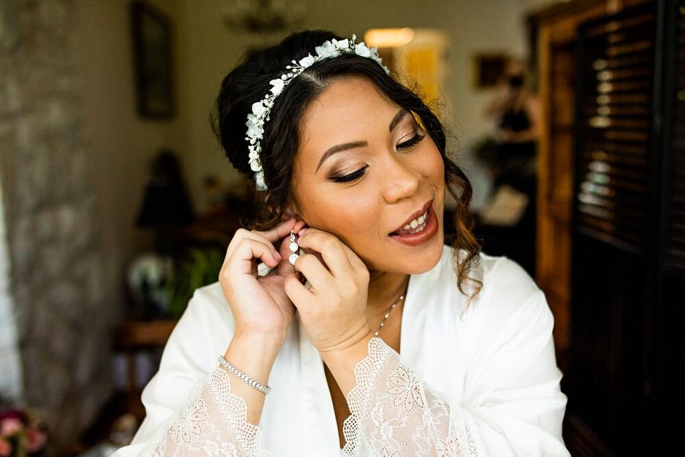 Bride putting on jewelery at her backyard wedding ceremony in BC